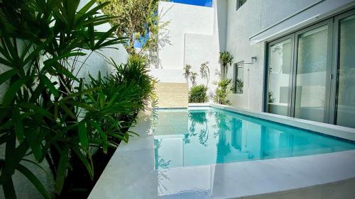 a swimming pool in front of a house at Stella w Pool Dorado Beach Resort 4BR in Mameyal