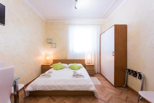 a bedroom with a bed with two green pillows at Apartment n3 in City Centre in Rome