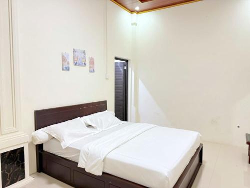 a bedroom with a bed with white sheets at HR Hotel Batu in Batu