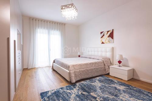 een witte slaapkamer met een bed en een blauw tapijt bij VITTO Luxury Apartment in Lecce