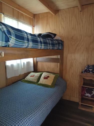 een slaapkamer met twee stapelbedden in een hut bij Cabañas Sandra Bucalemu Alto in Bucalemu