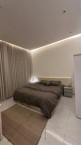 een bed in een witte kamer met afkeer bij شقة بصالة وغرفه نوم in Hafr Al Baten