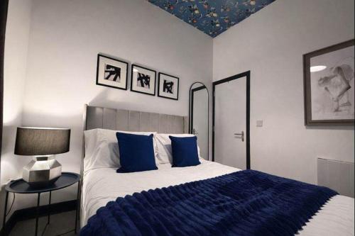 una camera da letto con un letto con lenzuola blu e una lampada di The Plaza, King 1 Bedroom Suite by The Hive WA1 a Warrington