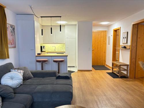 a living room with a couch and a kitchen at BergSee Apartament Laax in Laax