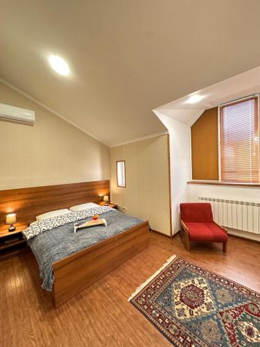 a bedroom with a bed and a red chair at Holiday Home Kanyon in Argel