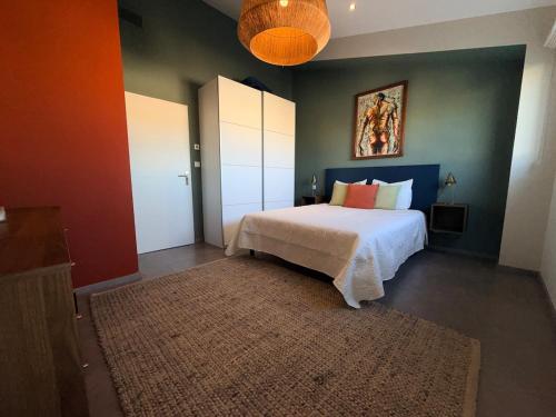 a bedroom with a bed and a painting on the wall at Urban Oasis - Duplex Design, Piscine privée in Perpignan
