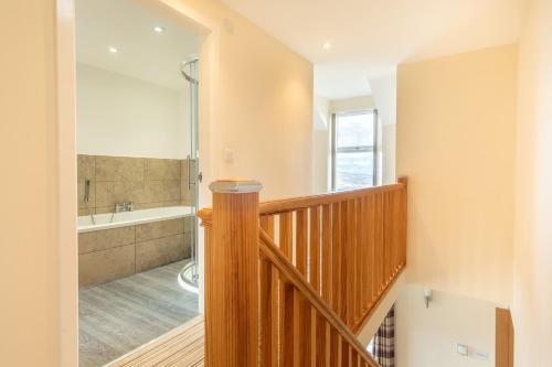 a staircase leading to a bathroom with a tub at Groeslon Uchaf in Caernarfon