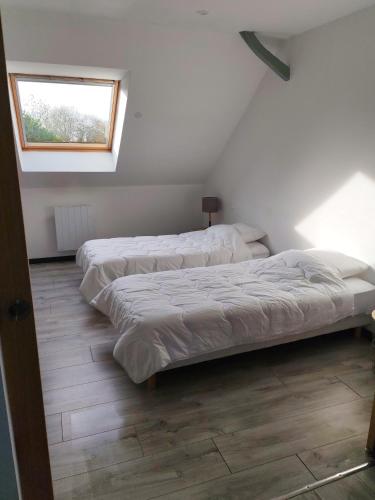 twee bedden in een kamer met een raam bij L'appart' Bivillais in Biville-sur-Mer