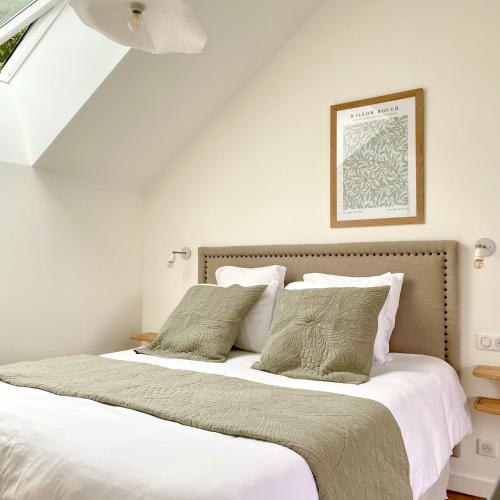 a bedroom with a bed with white sheets and pillows at La Cour Tellier in Rilly-la-Montagne