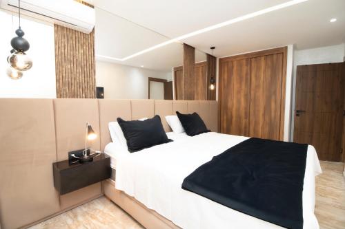 a bedroom with a large white bed with black pillows at Magnífico apartamento 19 in Casablanca