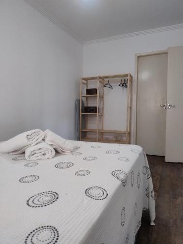 a bedroom with a bed with a blanket on it at Apartamento bem localizado com quintal privativo in Taubaté