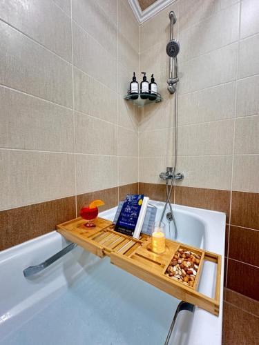 a bathroom with a bath tub with a tray on the bath tub at Holiday Home Kanyon in Argel