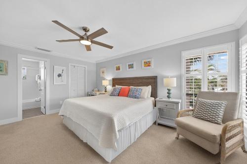 una camera con letto, ventilatore a soffitto e sedia di Blind Pass A205 a Sanibel