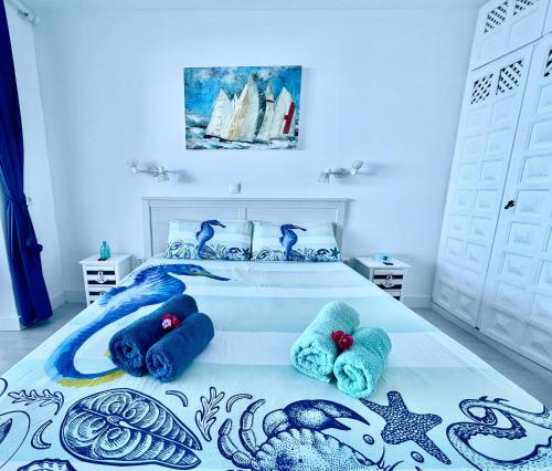 een slaapkamer met een bed met blauwe handdoeken erop bij Exclusive Ocean Views in Los Realejos