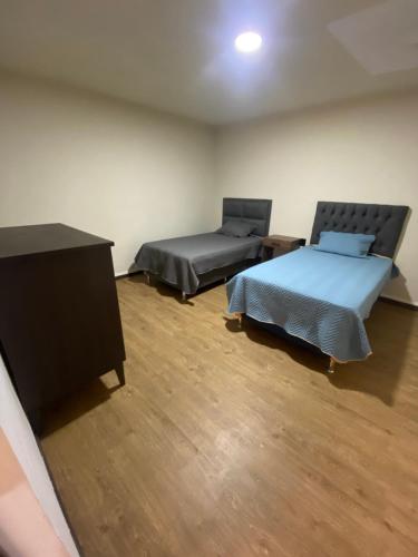 pokój z dwoma łóżkami i komodą w obiekcie DEPA Andres w mieście Cochabamba