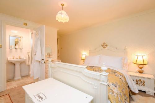 a white bedroom with a bed and a bathroom at Ladye Park in Liskeard