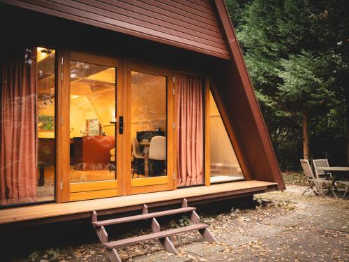 una casa con un banco delante de ella en Boshuisje Rekem - Sylva, en Lanaken