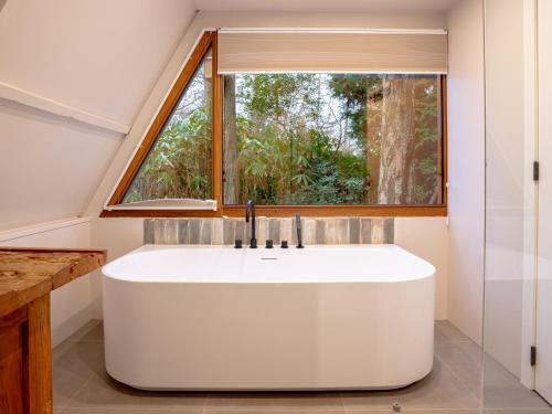 una bañera en un baño con ventana en Boshuisje Rekem - Sylva, en Lanaken