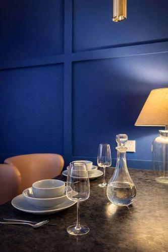 a table with two wine glasses and a vase at The Plaza, King 1 Bedroom Suite by The Hive WA1 in Warrington