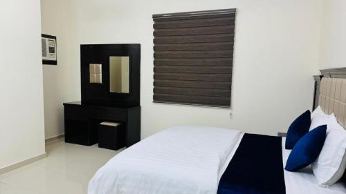 a bedroom with a bed and a mirror at شقق ترانيم السراة للشقق المخدومة - اقتصادي in Baljurashi