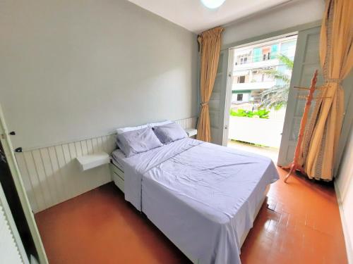 ein kleines Bett in einem Zimmer mit Fenster in der Unterkunft Apartamento na Sepé em Capão da canoa in Capão da Canoa