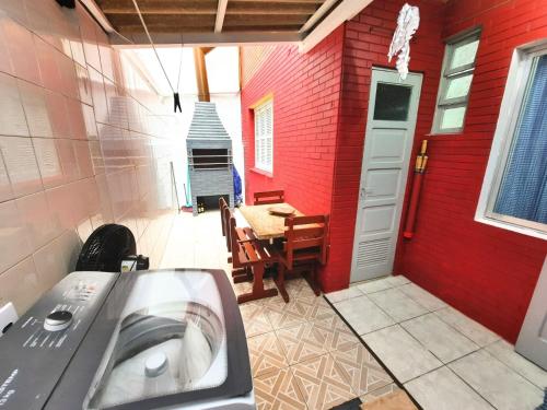 ein Badezimmer mit einem Waschbecken und einer roten Wand in der Unterkunft Apartamento na Sepé em Capão da canoa in Capão da Canoa