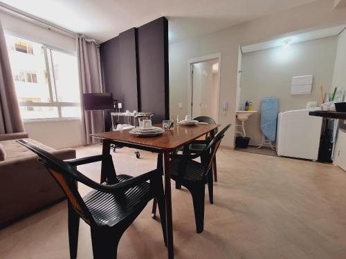 ein Esstisch und Stühle in einem Wohnzimmer in der Unterkunft Centro 15 in Belo Horizonte