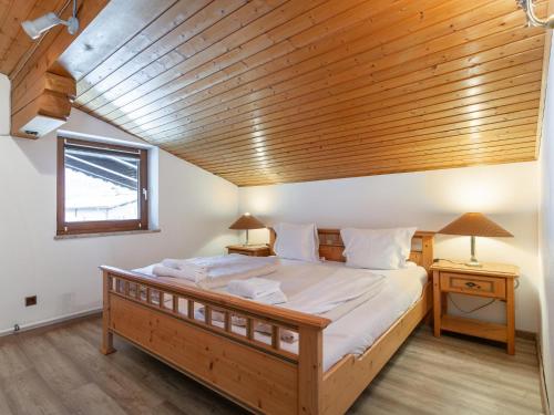 a large bed in a room with a wooden ceiling at FamilienLodge Reith in Reith bei Kitzbühel