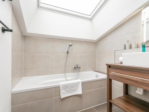 a bathroom with a bath tub and a sink at FamilienLodge Reith in Reith bei Kitzbühel