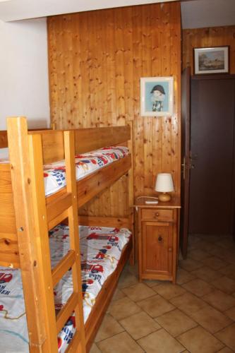een slaapkamer met 2 stapelbedden en een tafel met een lamp bij APPARTEMENTS MORILLON Village in Morillon