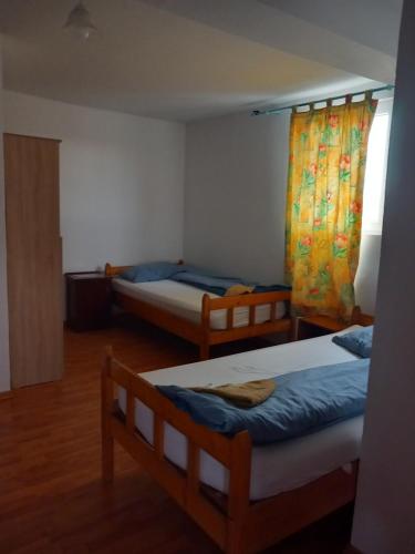 ein Zimmer mit zwei Betten und einem Fenster in der Unterkunft Liliacului in Marghita