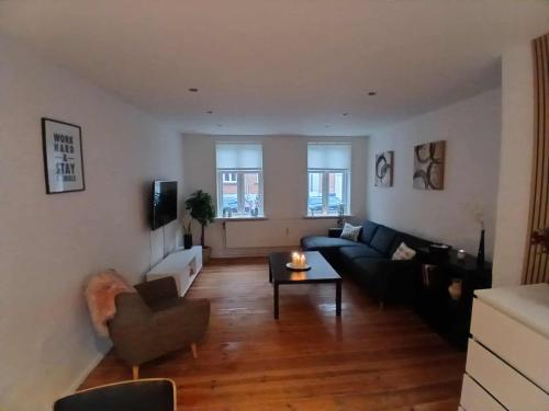 a living room with a couch and a table at Lejlighed ved stranden og centrum in Fredericia