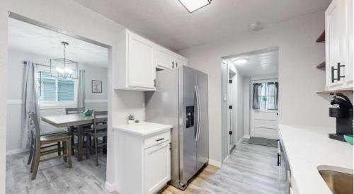 eine Küche und ein Esszimmer mit einem Tisch und einem Kühlschrank in der Unterkunft Modern Family Home with Three King Beds Near VA & Anschutz in Aurora