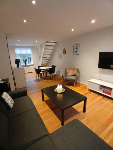 a living room with a couch and a table at Lejlighed ved stranden og centrum in Fredericia