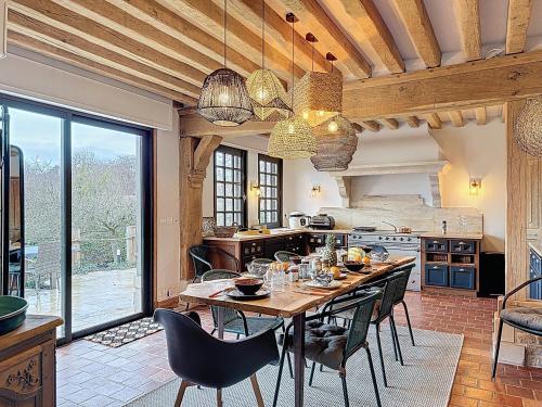 una cucina con tavolo in legno con sedie e una sala da pranzo di Villa Elysia YourHostHelper a Touques