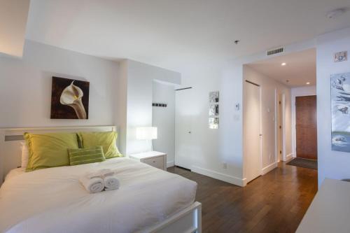 a bedroom with a large white bed with two bows at Les Immeubles Charlevoix - Le 1176 in Quebec City