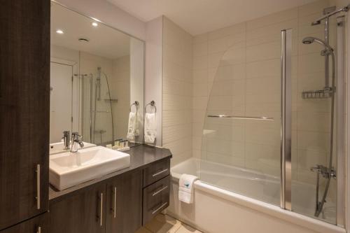 a bathroom with a tub and a sink and a shower at Les Immeubles Charlevoix - Le 1176 in Quebec City