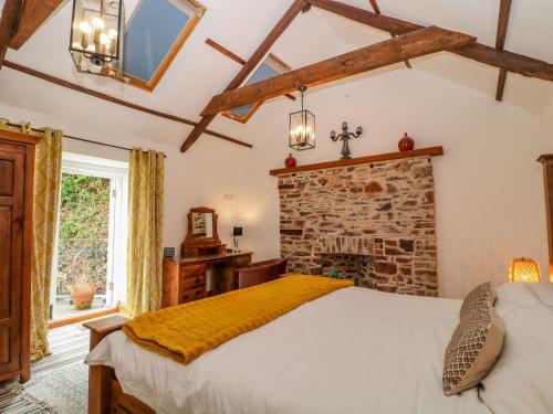 een slaapkamer met een bed en een stenen open haard bij Baywatch St David's View in Lynton