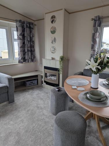 a living room with a table and a fireplace at SummerBreeze Retreat in Hartley
