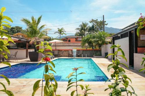 a swimming pool in the middle of a yard at VELINN Pousada Face Norte in Ilhabela