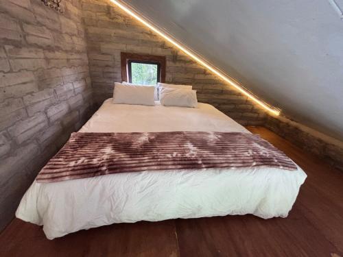 a bedroom with a bed in a brick wall at Bosch Rest in Pretoria