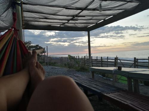 eine Person, die in einer Hängematte liegt und auf das Meer blickt in der Unterkunft Uncle Bob & Tere Beach House in Luna