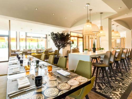 ein Esszimmer mit einem langen Tisch und Stühlen in der Unterkunft ibis Beaune La Ferme Aux Vins in Beaune