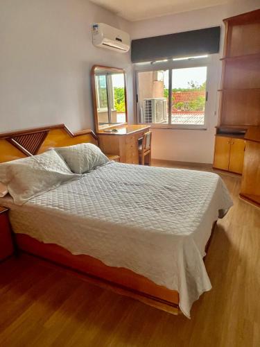 ein Schlafzimmer mit einem großen Bett und eine Küche in der Unterkunft Descanso garantido no centro de Foz in Foz do Iguaçu