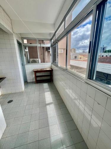 ein leeres Zimmer mit Fenstern und Fliesenboden in der Unterkunft Descanso garantido no centro de Foz in Foz do Iguaçu