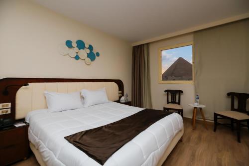Postel nebo postele na pokoji v ubytování Sahary Pyramids View Hotel