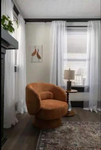 a brown chair in a living room with a window at 3BR Downtown-Old Salem Oasis in Winston-Salem