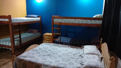 een kamer met 2 stapelbedden en een blauwe muur bij Duplex Luz de Sol in Las Toninas
