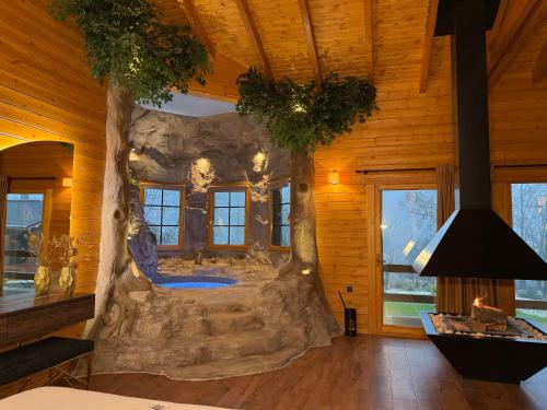 a room in a log cabin with a large tree monster bed at Cave Chalet - Waterfall Chalet in Eptalofos