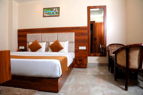 a bedroom with a bed and a table and a mirror at HOTEL ARSH RFESIDENCY in Haridwār